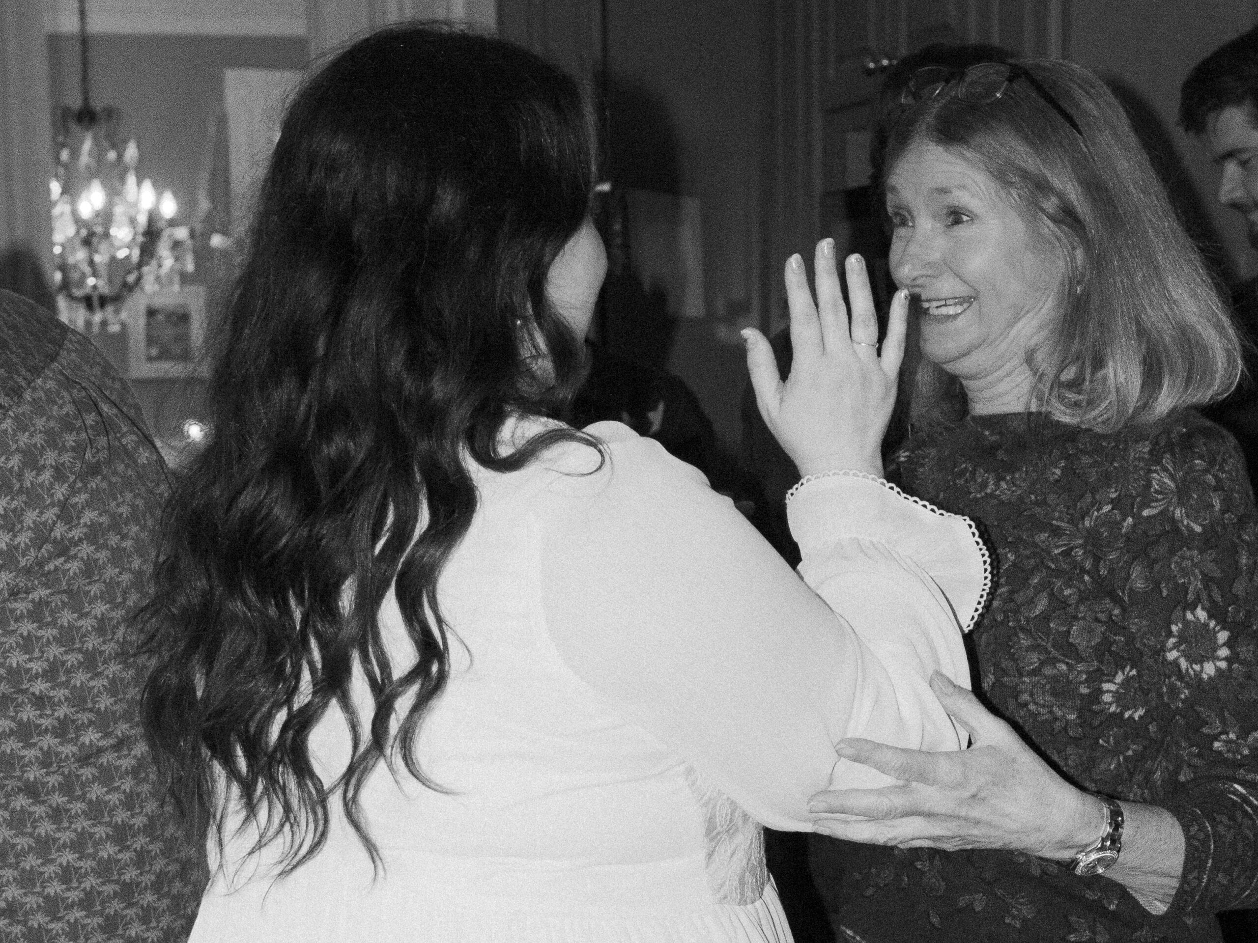 A newly engaged woman and her mother-in-law celebrate the engagement