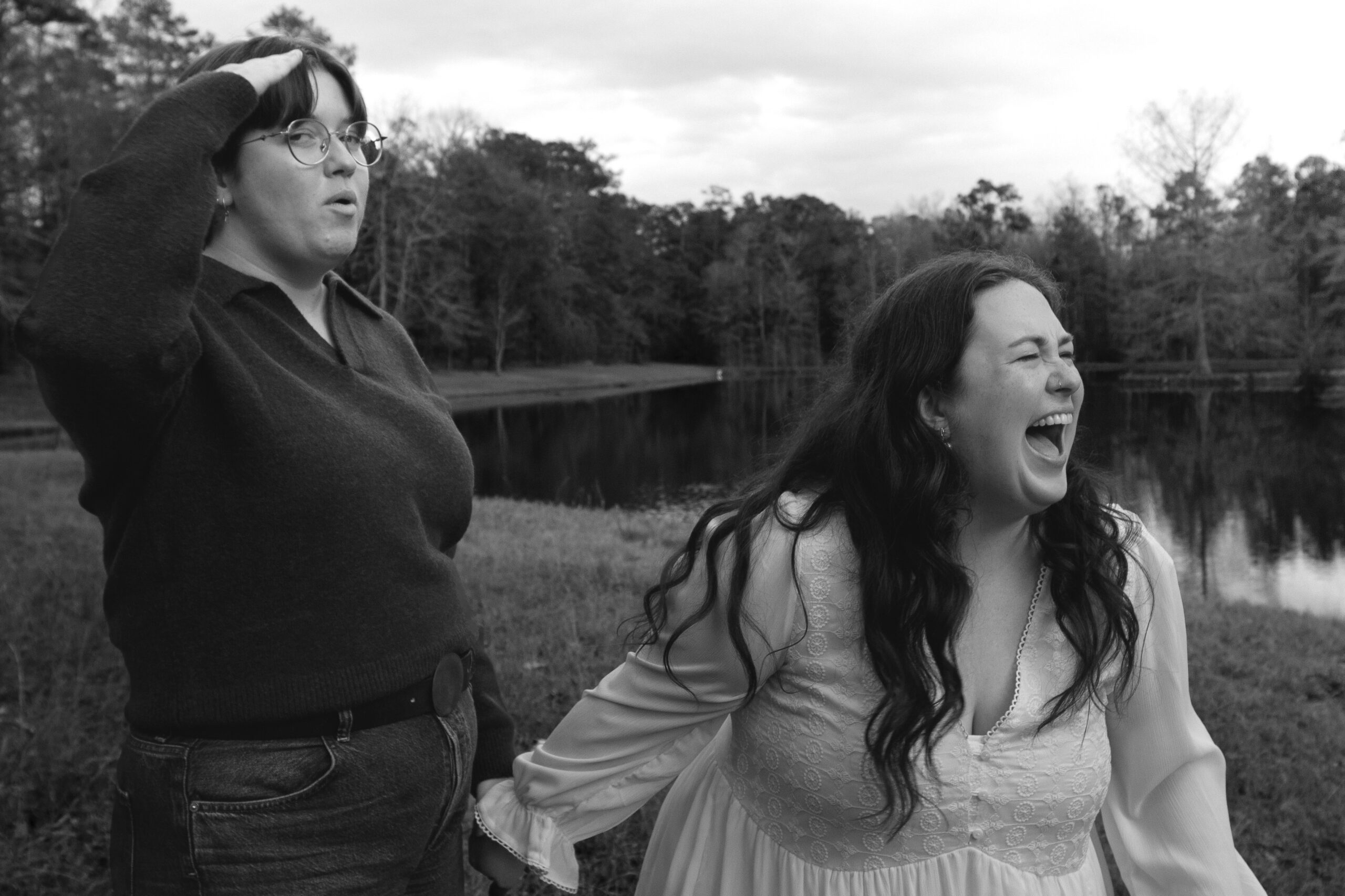 A queer couple celebrating their engagement by a clear lake