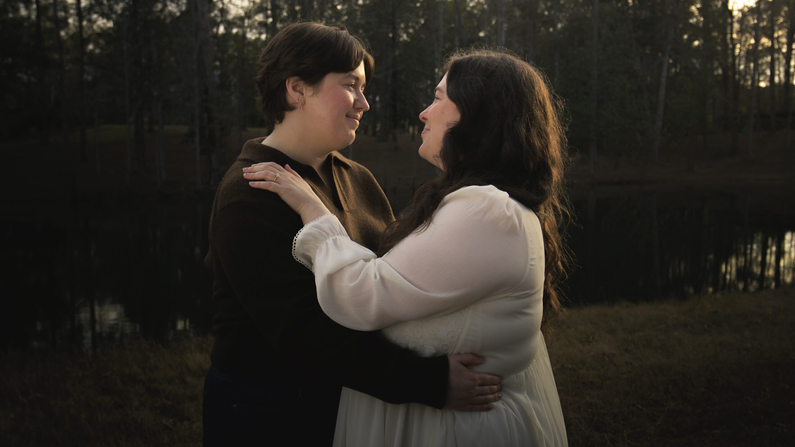 Two LGBTQ+ lovers dancing as the sun sets on a moody autumn evening in Thomasville GA
