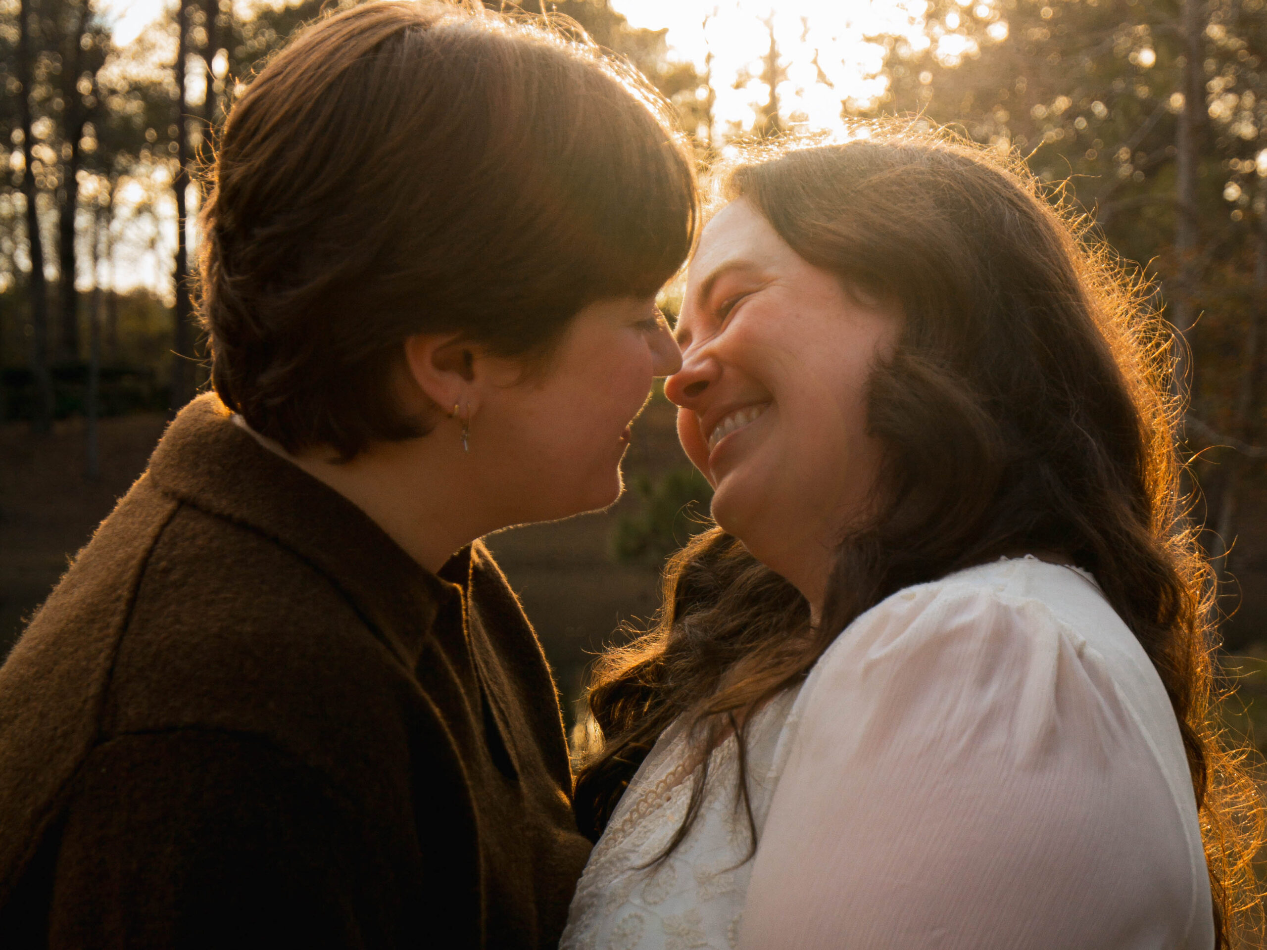 A queer couple kisses in hazy, golden light